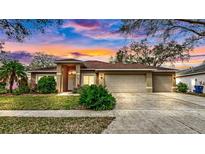 Inviting single-story home featuring a well-manicured lawn and a convenient three-car garage at 140 Sage Cir, Crystal Beach, FL 34681