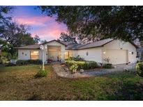 Charming one-story home with a landscaped front yard and inviting entryway at dusk at 1472 Ivydale Rd, Spring Hill, FL 34606