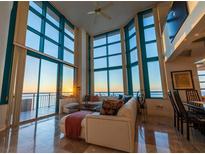Light-filled living room featuring walls of windows, tile flooring, and a comfortable seating area at 1520 Gulf Blvd # Ph1 1901, Clearwater Beach, FL 33767