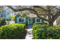 Charming green home with lush landscaping, teal shutters, and inviting walkway at 114 27Th N Ave, St Petersburg, FL 33704