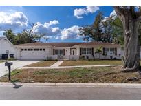 Charming single-story home featuring a white brick facade, attached garage, and well-maintained front yard at 13508 Greenleaf Dr, Tampa, FL 33613