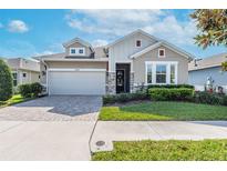 Beautiful single Gathering home with a well manicured lawn and a brick paver driveway at 14005 Kingfisher Glen Dr, Lithia, FL 33547