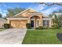 Charming single-Gathering home with well-manicured lawn, two car garage and beautiful, mature landscaping at 1788 Biarritz Cir, Tarpon Springs, FL 34689