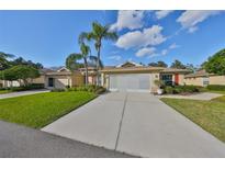 Charming home with well-maintained lawn, long driveway, red shutters, and lovely landscaping at 1912 Acadia Greens Dr, Sun City Center, FL 33573