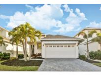 Charming home with a spacious driveway, manicured lawn, and beautiful tropical landscaping at 310 Blackrock Ln, Apollo Beach, FL 33572