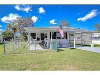 Charming single-story home featuring a fenced yard, covered porch, and an American flag waving proudly at 4529 Olive Dr, Zephyrhills, FL 33542