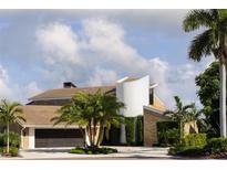 Stunning home featuring unique architectural design, lush landscaping, and a circular driveway, creating an inviting curb appeal at 4900 59Th S Ave, St Petersburg, FL 33715