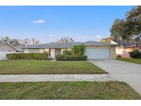 Charming single-story home with manicured lawn and stone accents on the facade at 6104 Dory Way, Tampa, FL 33615