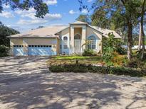 Charming home with a three-car garage and lush landscaping at 1001 Bayvista Dr, Tarpon Springs, FL 34689