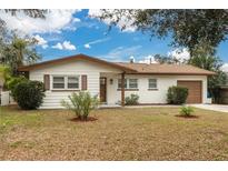 Charming single-story home featuring a well-manicured front yard and a classic brick and siding exterior at 121 Shirley Dr, Largo, FL 33770