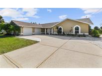 Charming home featuring a three-car garage and a well-maintained lawn with a circular driveway at 12769 Foresman Blvd, Port Charlotte, FL 33981