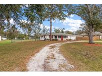 Wide view of a single-story home with a well-kept lawn and decorative front yard at 12845 95Th N St, Largo, FL 33773