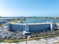 Wide angle view of Shore Towers Condominium overlooking the bay with a lush green lawn and mature landscaping at 1868 Shore S Dr # 602, South Pasadena, FL 33707