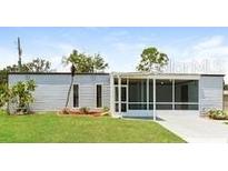 View of the home's exterior, featuring a screened-in porch and well-maintained lawn at 2054 Pennsylvania Ave, Englewood, FL 34224