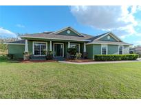 Charming single-story green home with manicured lawn and stone accents at 3206 Duchess Ct, Plant City, FL 33565