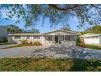 Charming single-story home featuring a lovely front porch and well-maintained landscaping at 1489 77Th N Ave, St Petersburg, FL 33702