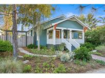 Charming blue home showcasing a quaint front porch, lovely landscaping, and inviting curb appeal at 202 13Th N Ave, St Petersburg, FL 33701