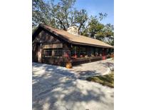 Charming single-story home with a stone chimney, flower boxes and beautiful brickwork leading to the front door at 3010 County Road 31, Clearwater, FL 33759