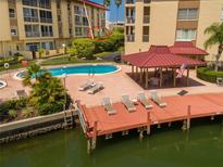 Resort-style pool, dock, and patio furniture at waterfront community at 105 Island Way # 121, Clearwater Beach, FL 33767