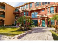 Inviting exterior of a multi-story building with landscaping and a paved walkway at 2717 Via Cipriani # 631B, Clearwater, FL 33764