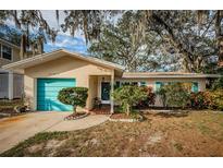 Charming single-story home with teal garage door and landscaped yard at 335 Tucker St, Safety Harbor, FL 34695