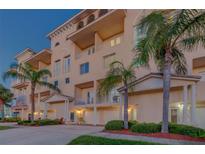 Tan three-story building with multiple balconies, palm trees, and attached garages at 605 Poinsettia Ave # 5, Clearwater, FL 33767