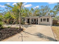 Charming single-story home featuring a spacious driveway, well-manicured landscaping, and a cozy covered porch at 1736 W Manor Ave, Clearwater, FL 33765