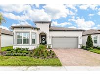 Attractive one-story home with gray garage door and landscaped front yard at 5858 Shorebird Br, Land O Lakes, FL 34638