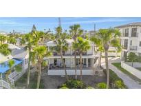 Inviting multi-story home featuring balconies and lush palm trees, offering a tropical and serene living environment at 108 14Th Ave # 3, St Pete Beach, FL 33706