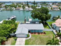 Aerial view of waterfront home with private dock and solar panels at 11600 7Th E St, Treasure Island, FL 33706