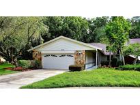 Single-story house with a two-car garage and nicely landscaped lawn at 3529 Tanglewood Trl, Palm Harbor, FL 34685