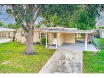 Cute yellow house with carport and mature landscaping at 10162 115Th Ave, Largo, FL 33773