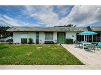 Front view of a single story home with green door and patio at 7787 39Th N Ter # 7787, St Petersburg, FL 33709