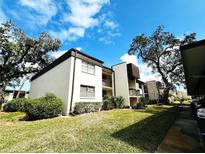 Inviting two-story condo featuring well-maintained landscaping, charming balconies, and beautiful trees at 2400 Winding Creek Blvd # 25-101, Clearwater, FL 33761