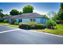 Single-story home with light blue exterior, landscaped lawn, and paved driveway at 8356 Candlewood Rd # 0, Seminole, FL 33777