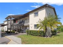 Two-story condo building with covered parking and lush landscaping at 4849 Onyx Ln # 106, New Port Richey, FL 34652