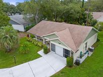 Single-story house with a driveway and landscaped yard in a residential neighborhood at 2241 Merion Ct, Spring Hill, FL 34606