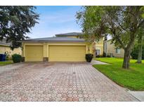 Two-story house with a three-car garage and a well-manicured lawn at 1545 Regal Mist Loop, Trinity, FL 34655