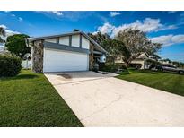 Single-story home with a white garage door and well-manicured lawn at 3631 Player Dr, New Port Richey, FL 34655