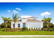 White one-story house with a two-car garage and palm trees at 10005 Zennia Ln, Parrish, FL 34219