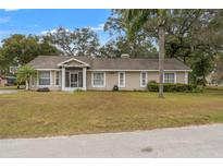 Single-story home with a screened porch and landscaped yard at 37351 Neighbors Path, Zephyrhills, FL 33542