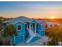 Luxury waterfront home with a two-car garage, stunning sunset views, and a spacious driveway at 7516 Gulf Way, Hudson, FL 34667