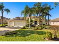 Beautiful home with three-car garage, lush landscaping, and palm trees at 13235 Legends Trl, Dade City, FL 33525