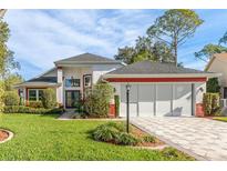 Beautiful two-story home with a red accent and lush landscaping at 2476 Silkwood Ct, Spring Hill, FL 34606