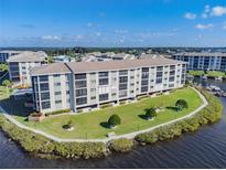 Aerial view of waterfront condo building with lush landscaping and parking at 8150 Brent St # 746, Port Richey, FL 34668
