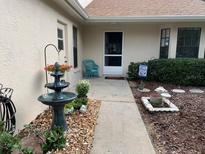 Inviting front patio with fountain, landscaping, and walkway at 13219 Greenview Ct, Hudson, FL 34669