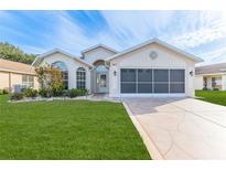 Tan one-story house with a two-car garage and well-manicured lawn at 262 Hartford Ct, Spring Hill, FL 34609