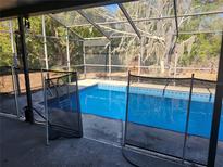 Inviting screened pool with safety fence at 6141 Freeport Dr, Spring Hill, FL 34606