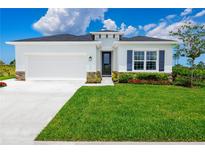 One-story home with white exterior, gray accents, and a lush green lawn at 10008 Zennia Ln, Parrish, FL 34219