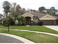 Single-story home with brick facade, tile roof, and two-car garage at 1855 Eau Claire Ct, Oldsmar, FL 34677